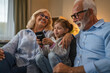 © Miljan Živković - grandmother and grand father enjoy while watch grandchild how use game pad