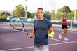 © JackF - Positive adult sportsman looking at camera while playing tennis at court outdoor