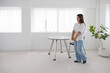 © hidez - Woman walking with laptop and documents in bright office interior