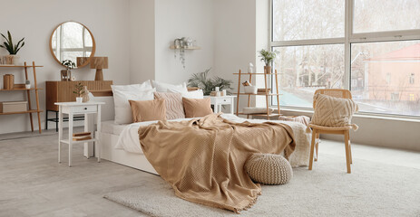 Wall Mural - Stylish interior of bedroom with comfortable bed and chair with cushion