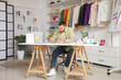 © Pixel-Shot - Happy male stylist working with sketches at table in studio