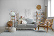© Pixel-Shot - Interior of stylish living room with grey sofa, shelving unit and armchair
