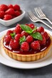 © kardaska - Raspberry tart with fresh mint on white plate