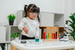 © geargodz - toddler girl scientist making chemical test with test tube and beaker. learning science