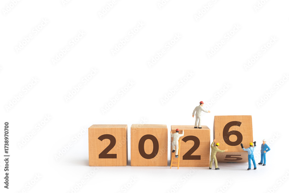 Transitioning from 2025 to 2026 with wooden blocks and miniature people ...