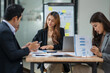 © aekachai - Group of Asian businesspeople sits down for a business investment planning meeting.