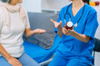 © ArLawKa - Doctor is examining elderly female patient in ward while doctor is checking her condition in recovery room. Medical and healthcare concept.