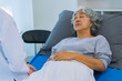 © ArLawKa - Doctor is examining elderly female patient in ward while doctor is checking her condition in recovery room. Medical and healthcare concept.