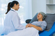 © ArLawKa - Doctor is examining elderly female patient in ward while doctor is checking her condition in recovery room. Medical and healthcare concept.