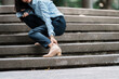© crizzystudio - Young woman experiencing ankle pain on stairs