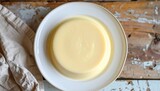 budino alla vaniglia su un piatto bianco su un tavolo di legno, vista dall'alto, food photography