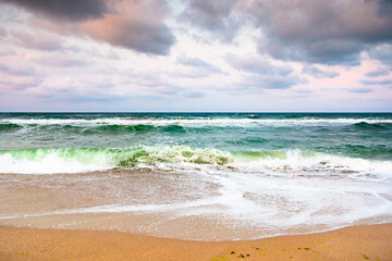 Wall Mural - dramatic beach outdoor background. scenic coast and sky with clouds. beautiful seascape. wave bring foam on golden sand