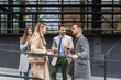 © Srdjan - IT experts freelance workers innovative technology developers, working on a new project staff meeting with casual talk in formalwear outside office building before the work. Discussing business people