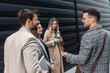 © Srdjan - IT experts freelance workers innovative technology developers, working on a new project staff meeting with casual talk in formalwear outside office building before the work. Discussing business people