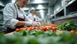 © Pete - Young female cooks prepare fresh food ingredients in busy pro kitchen. Meticulously handle ripe red tomatoes, crisp green vegetables on light wood counter. Chefs work fast focusing on efficient meal