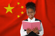 © New Africa - Little girl with book against flag of China. Language school