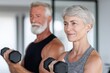 © id512 - Active senior couple lifting dumbbells together in gym, embracing fitness, health and energetic aging lifestyle
