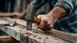 © PACHARA - A man is holding a hammer and is about to hit a nail