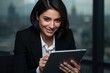© The 2R Artificiality - Professional businesswoman smiling while reading news on a digital tablet in modern office setting with blurred city background and natural light.