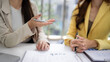 © STBSTD - Adult Asian businesswomen discuss financial reports analyze data collaborate strategize project planning sharing ideas modern office meeting professional workspace