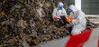 © BESTIMAGE - Emergency response team in protective suits and masks working at a disaster site with debris and soil, conducting assessment and cleanup operations in hazardous environment
