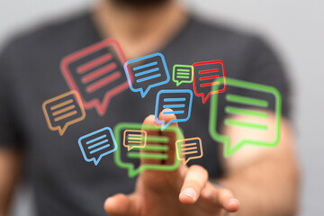 Hand pointing to colorful message bubbles, representing online communication, social media interaction and modern technology (144 chars max)