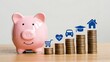 © Fatma - Pink piggy bank and ascending stacks of coins topped with icons representing savings goals like health education car home and shopping symbolizing financial planning and investment for a secure future
