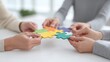 © Preeyanuch - Hands assembling a colorful puzzle, symbolizing teamwork and collaboration.
