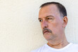 © Horacio Selva - Adult male with mustache sitting indoors wearing white t-shirt.