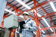 © DG PhotoStock - Engineer checking control panel in factory, updating software with tablet.