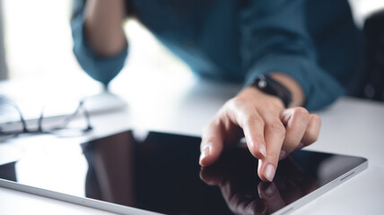 Wall Mural - Close up, business woman using digital tablet with laptop computer on office table. Woman finger touching on tablet screen, searching the information, internet networking at workplace