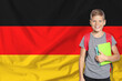 © New Africa - Little boy with backpack against flag of Germany. Language school