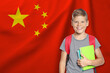 © New Africa - Little boy with backpack against flag of China. Language school