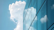 © Mahemud - A close-up view of modern building glass architecture with a cloudy sky reflected on the facade.