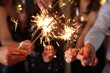© New Africa - Friends celebrating New Year with sparklers and wine glasses indoors, closeup