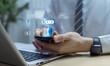 © Father_Studio - Chatbot and customer support concept with person using smartphone beside laptop, showing chat bubbles, call, and mic icons, representing AI assistant, automation, and omnichannel service.