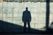© Ilia - Shadow of a person on a concrete wall in urban environment