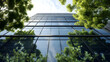 © Mahemud - A sustainable glass office building with trees, designed to reduce carbon dioxide emissions - an eco-friendly addition to the modern city skyline.