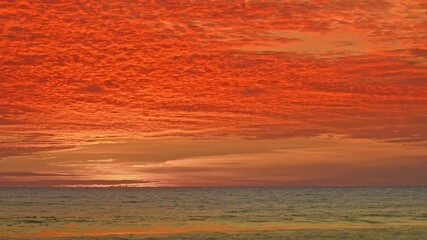 Wall Mural - As the sun sinks below the horizon, the clouds ignite with radiant light, creating a dreamy, romantic glow over Karon Beach. A breathtaking sunset unfolds, where fiery skies meet serene waters