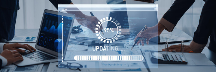 Wall Mural - Group of business professionals working together in a modern office setting with digital interface showing progress update on project development and data analysis. Trope