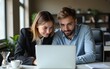 © wang - Two professionals collaborating on a laptop in an office setting. High quality