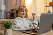 © Andrii Iemelianenko - Young girl looking at laptop screen typing keyboard, learning programming online with great enthusiasm. Child celebrating in excitement after achieving positive result working education study progress