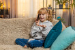 © Andrii Iemelianenko - Young teenager girl calling phone mother at home, speaking eagerly and pausing to listen with patient nods. Blonde child kid on sofa shares daily tales, conversation with friendly details and laughter
