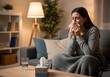 © AlfaSmart - Woman with cold or allergies relaxing at home in cozy living room with tissues and blanket for comfort and relief