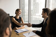 © fizkes - Two business partners man woman handshake reach agreement on negotiation
