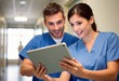 © Aliaksandr Barouski - Healthcare professionals review tablet together in a clinical hallway