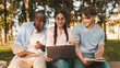 © Prostock-studio - Accepted students. Joyful diverse friends celebrating success with laptop computer outdoors, cheering successful exam pass, sitting in parkland