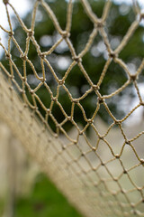 Close-up of a handmade fishing net with a soft green background