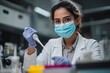 © VolumeThings - Young Hispanic woman in lab coat and mask using pipette in a lab