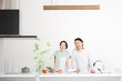 © kapinon - A smiling middle-aged couple posing for the camera in the kitchen